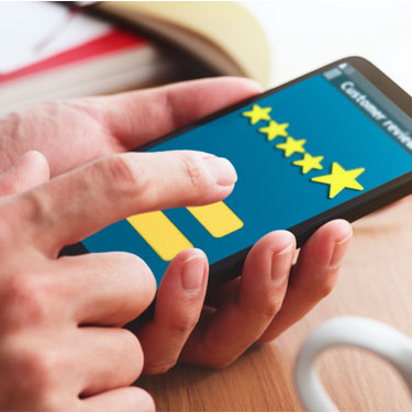 hands filling out 5 star review on mobile device
