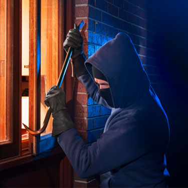 burglar prying open window with crowbar